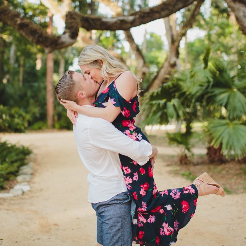 man lifting woman off ground and kissing her