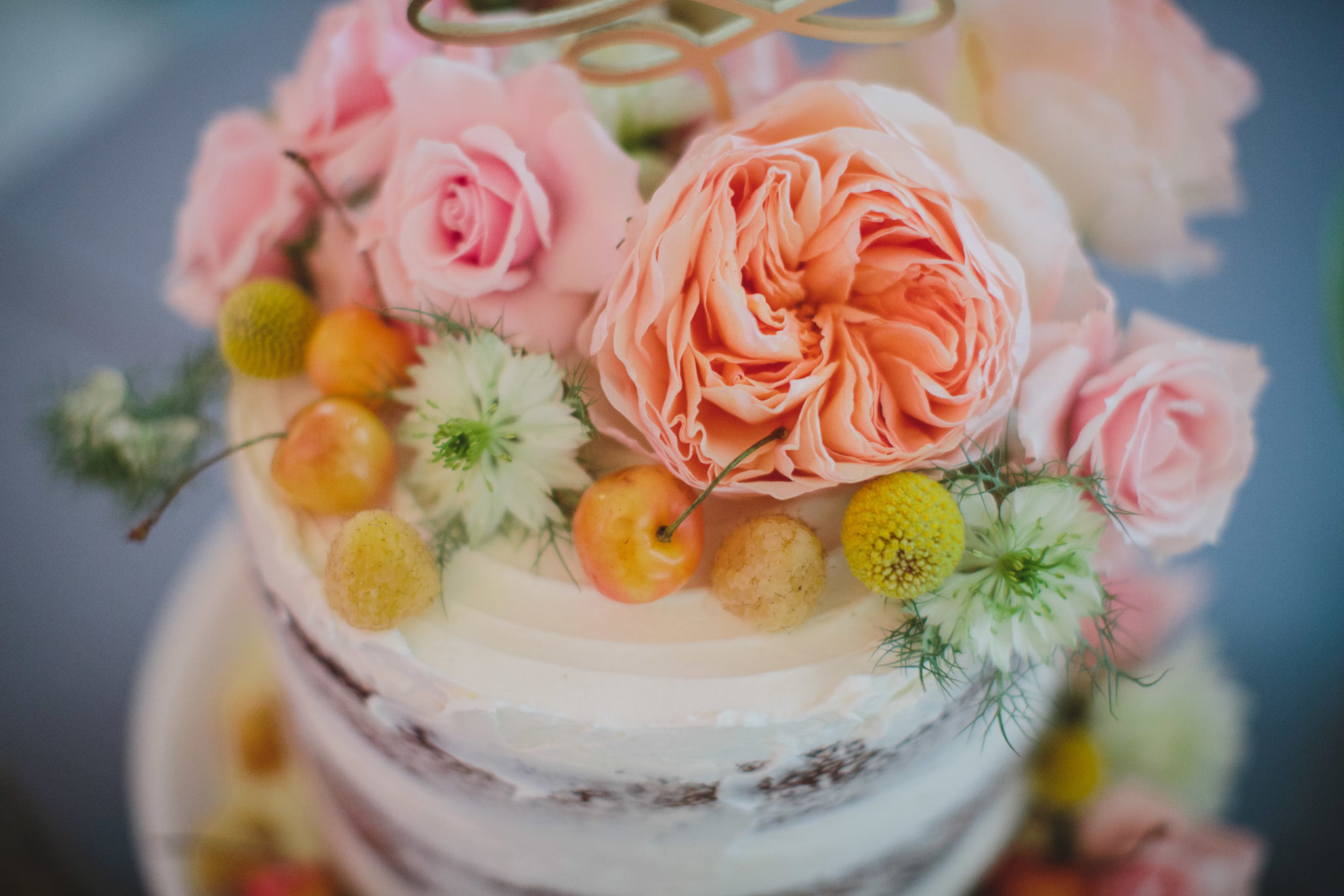 one tiered wedding cake with white frosting, florals and cherries