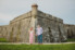couple standing in front of historic fort in st. augustine