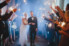 groom and bride walking through sparklers