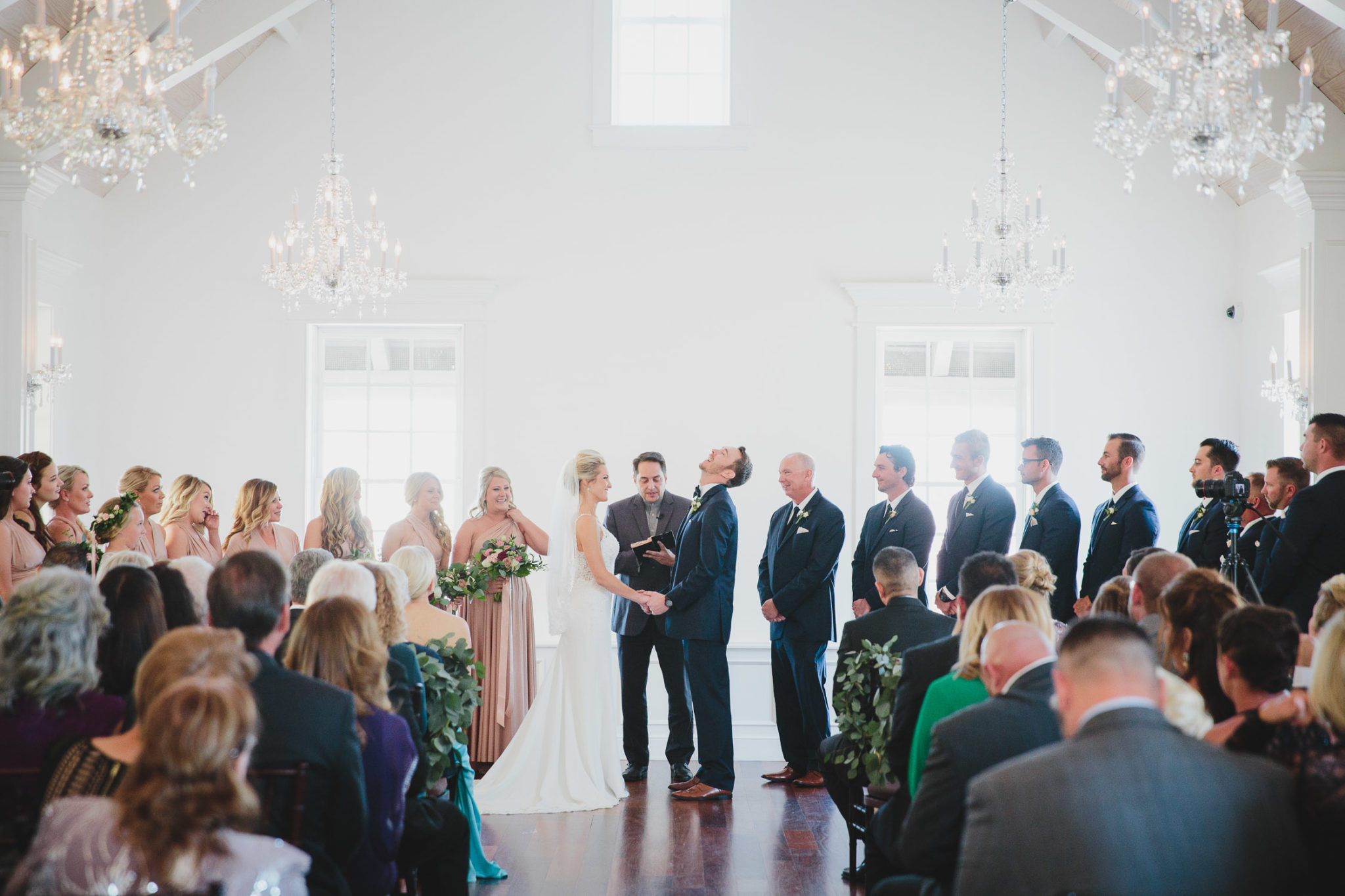 groom throwing back head laughing during ceremony at villa blanca