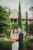 groom holding bride standing in front of gardens at club continental