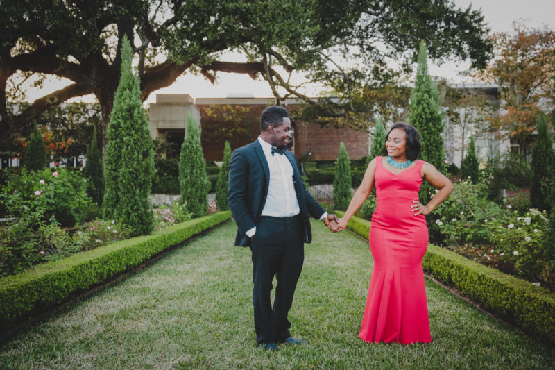 couple standing in cummer museum gardens holding hands while dressed up in formal attire