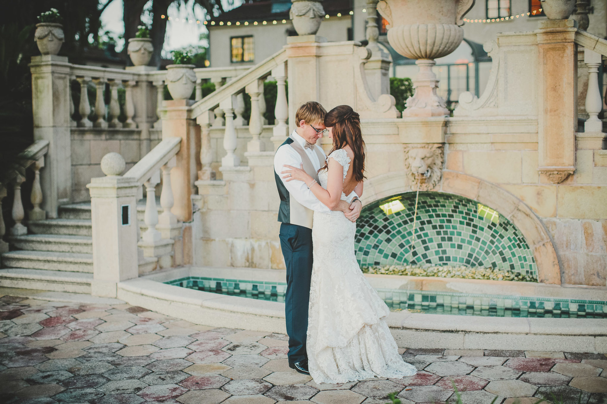 groom and bride looking at each other and hugging in front of fountain at epping forest