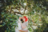 groom with green hair and bride with orange hair under tree branches