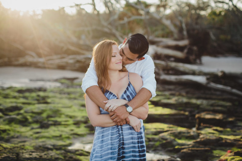 man kissing woman's cheek while hugging her at little talbot island