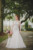bride looking to side holding bouquet of burgundy, pink and white flowers