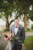 groom standing in front of ribault club holding bridal bouquet