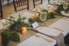 table runner of greenery, candles and geometric details at wedding reception