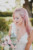 bride with pink hair looking down at pink and white bridal bouquet