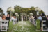 mirror stands holding tall floral vases lining aisle at outdoors spa lawn ceremony