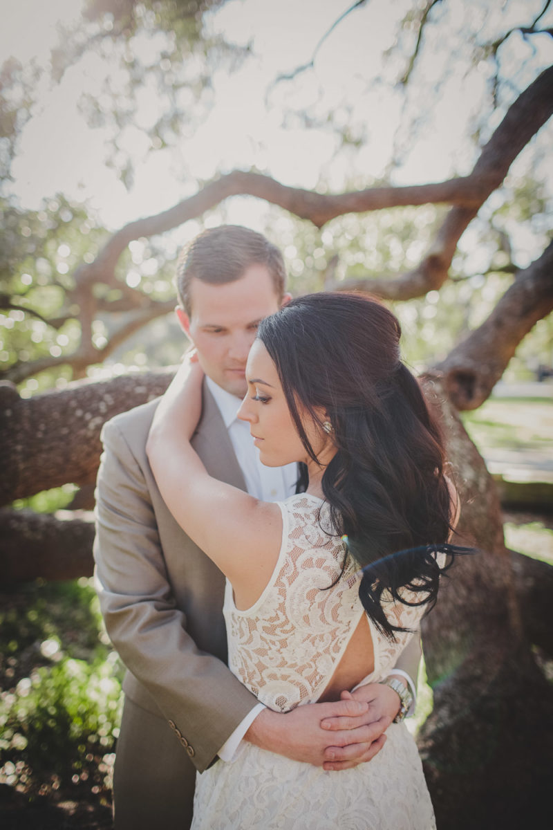 couple hugging with large oak tree branches surrounding them