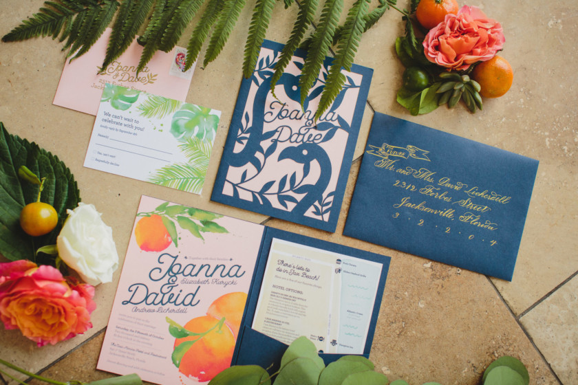 wedding invitation with citrus and flamingos on them