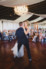 groom lifting bride off her feet on dance floor during first dance in grand ballroom