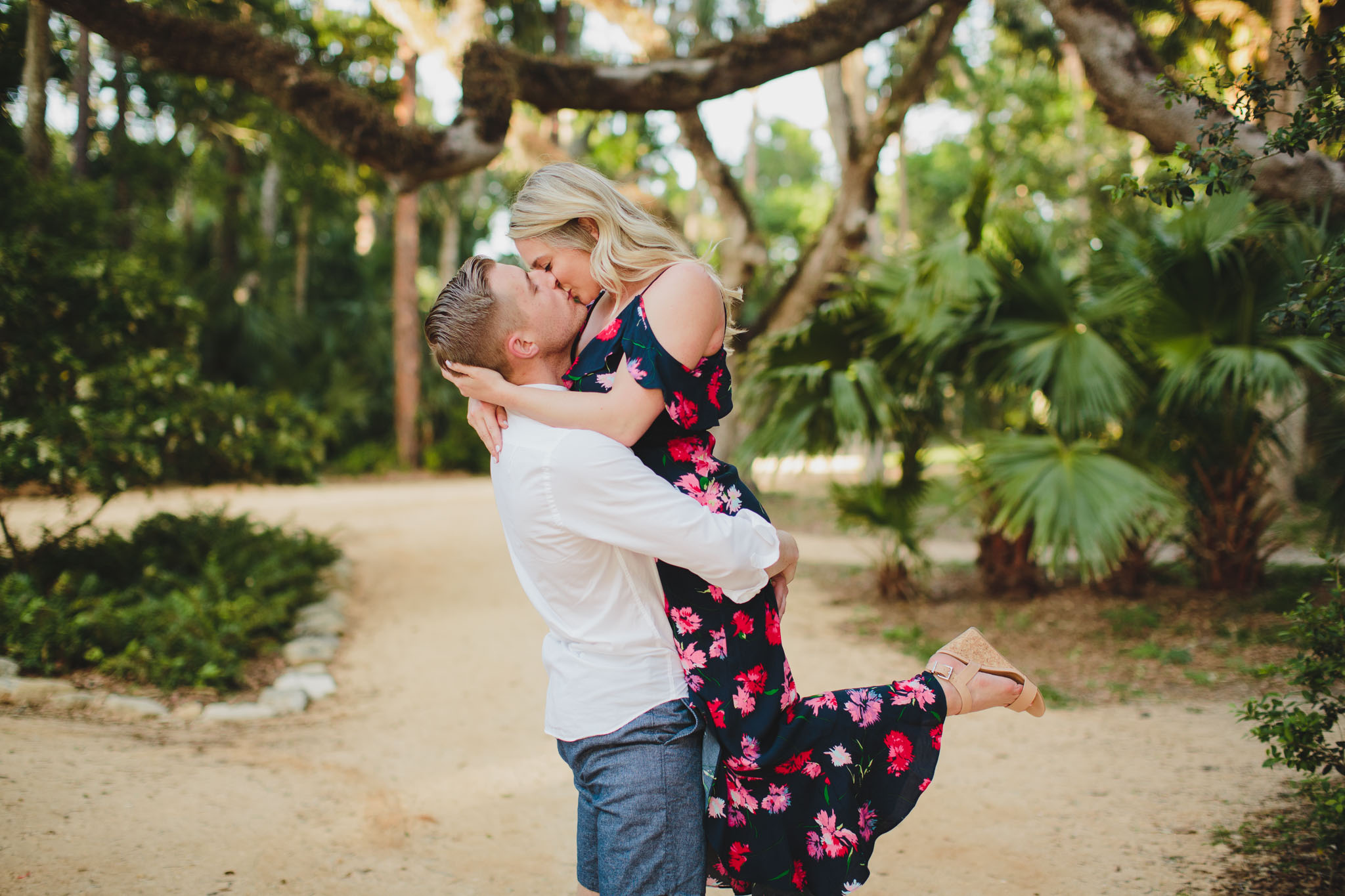 man lifting and kissing woman in washington oaks park and gardens