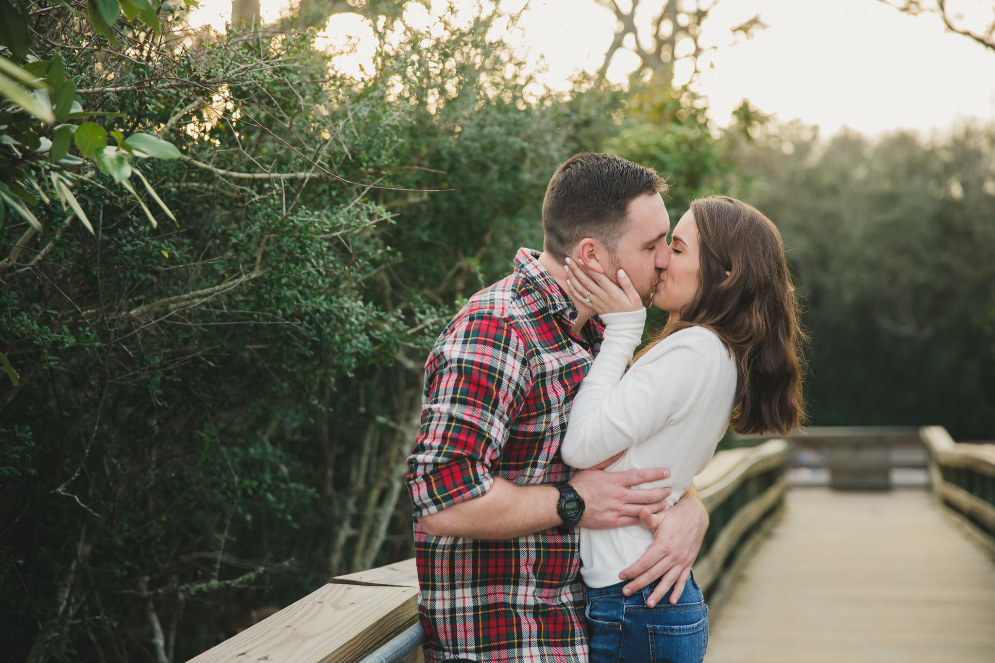 couple kissing on boardwalk during engagement session