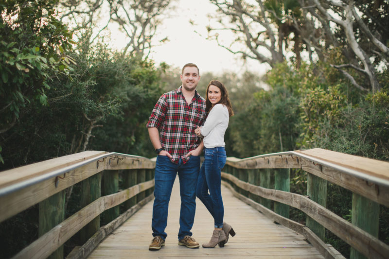 couple standing on boardwalk to beach