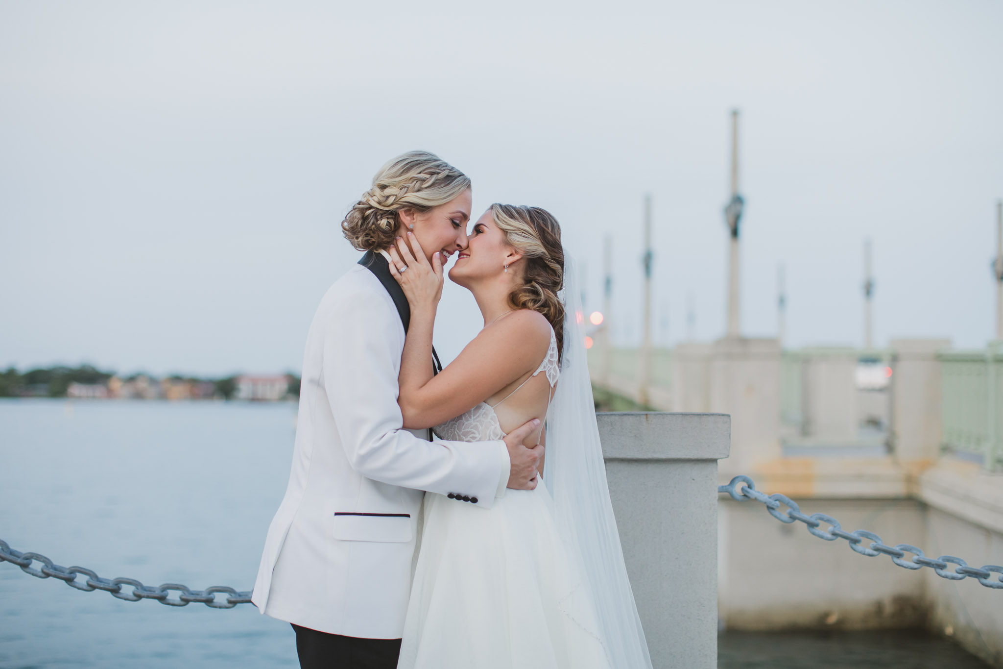 lesbian brides kissing in front of st. augustine bay bridge of lions