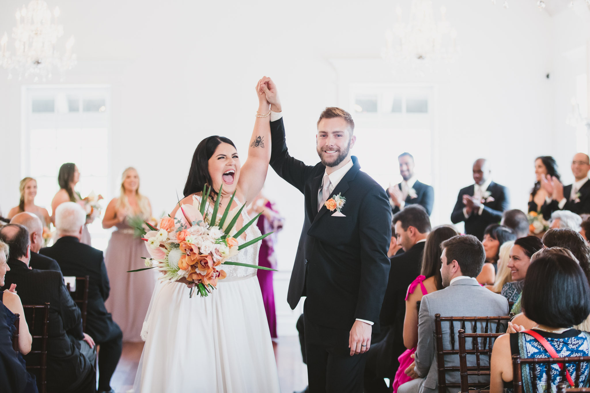 bride and groom high five each other walking down the aisle after ceremony at villa blanca