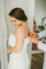 bride getting dressed zipped up in the white room bridal suite