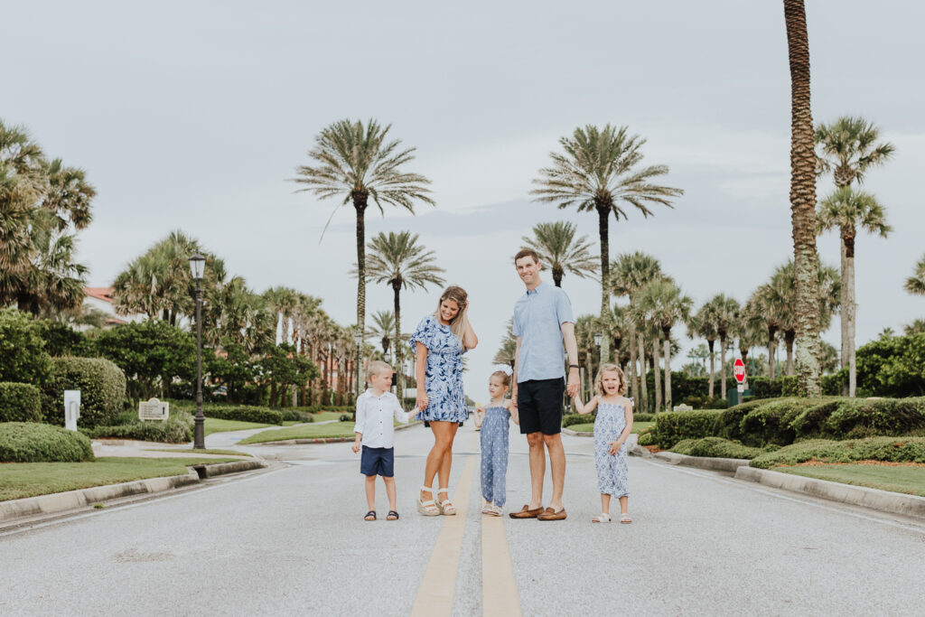 mom and dad standing with their three kids in middle of ponte vedra street for portrait