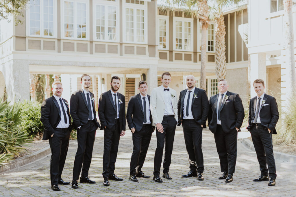 groom with his groomsmen standing outside of oyster bay in amelia island