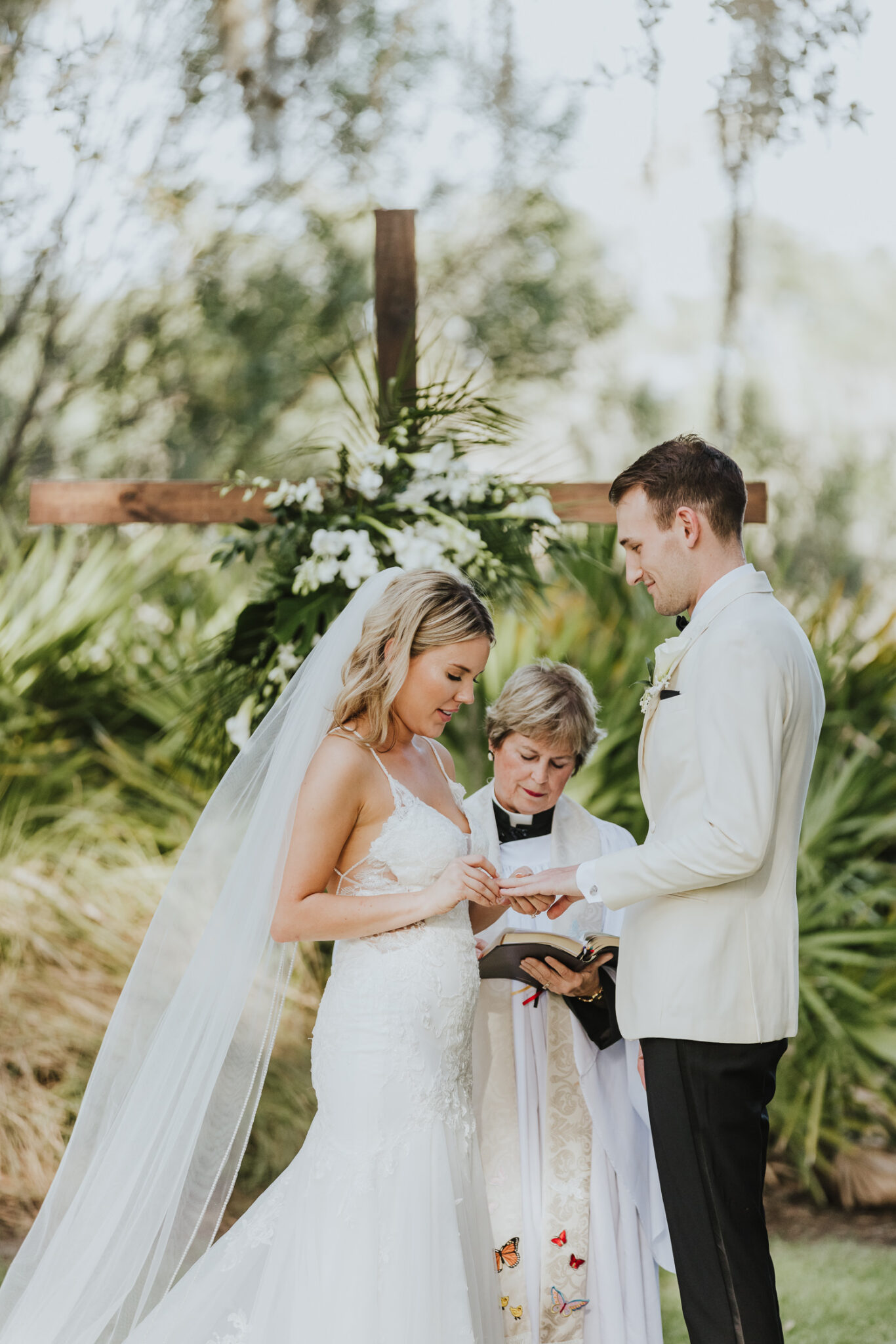 bride putting ring on groom's finger during outdoors ceremony at oyster bay yacht club 