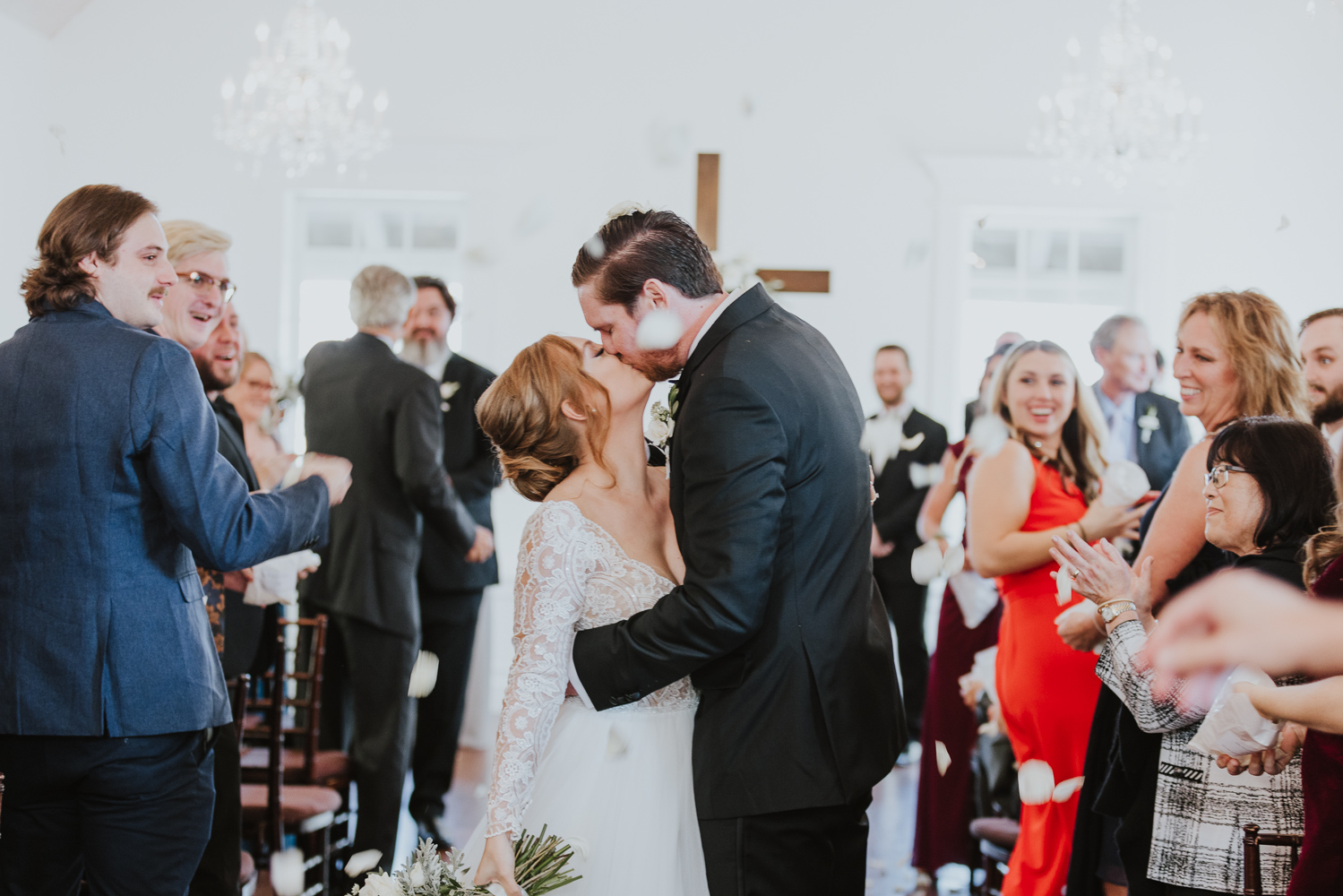 bride and groom kissing with guests throwing petals during villa blanca recessional 