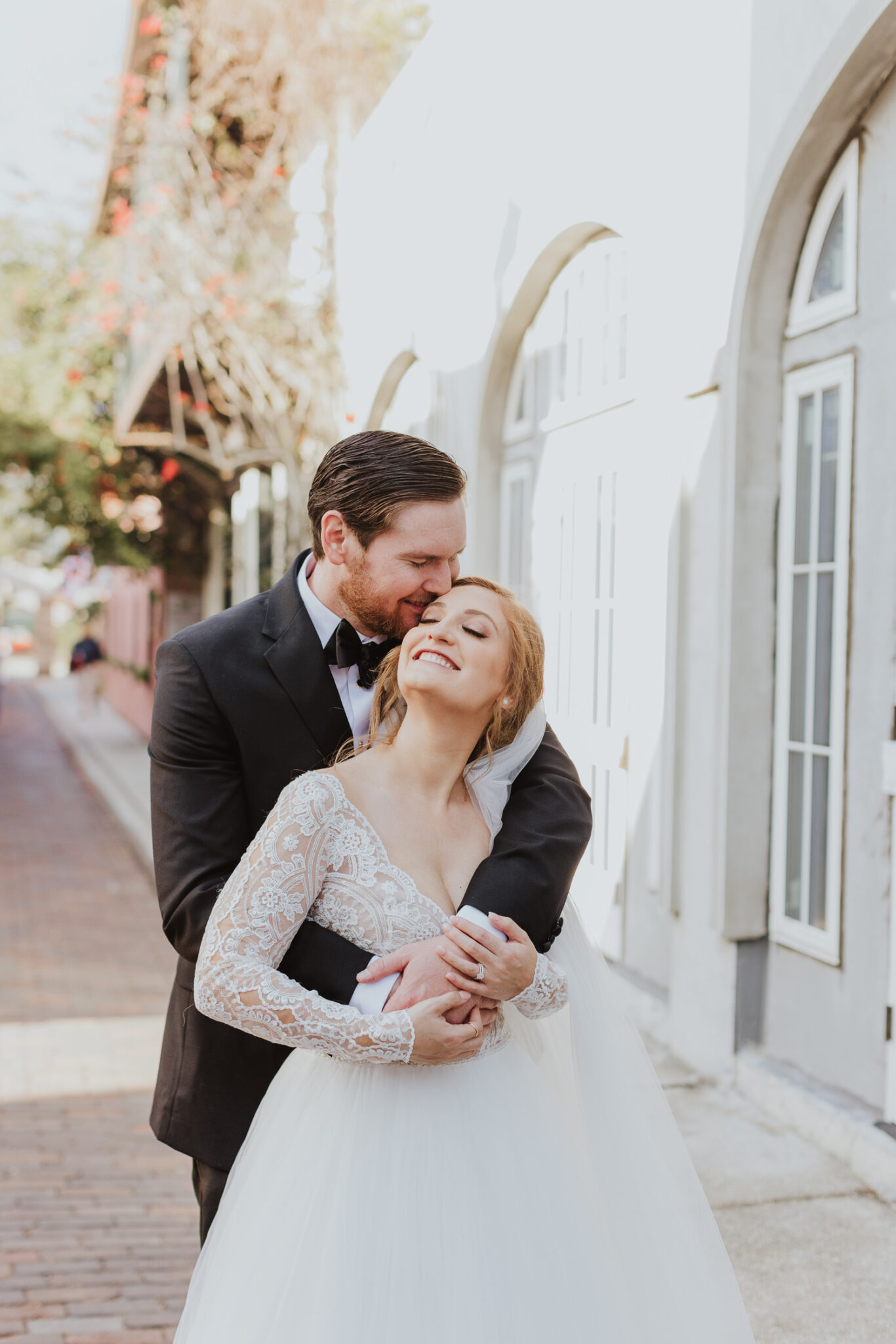 groom hugging and kissing bride's temple during couples portraits downtown st. augustine