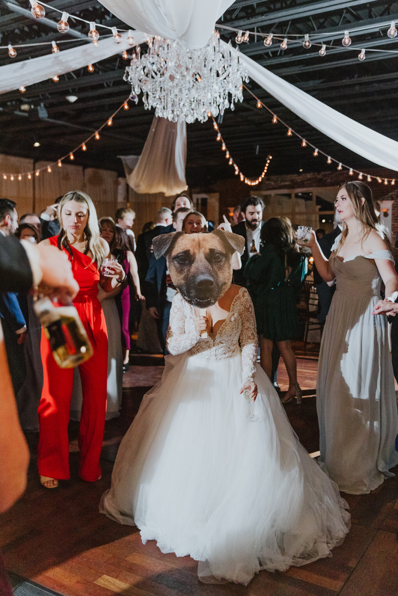 bride holding a picture of her dog in front of her face while dancing at her wedding reception 