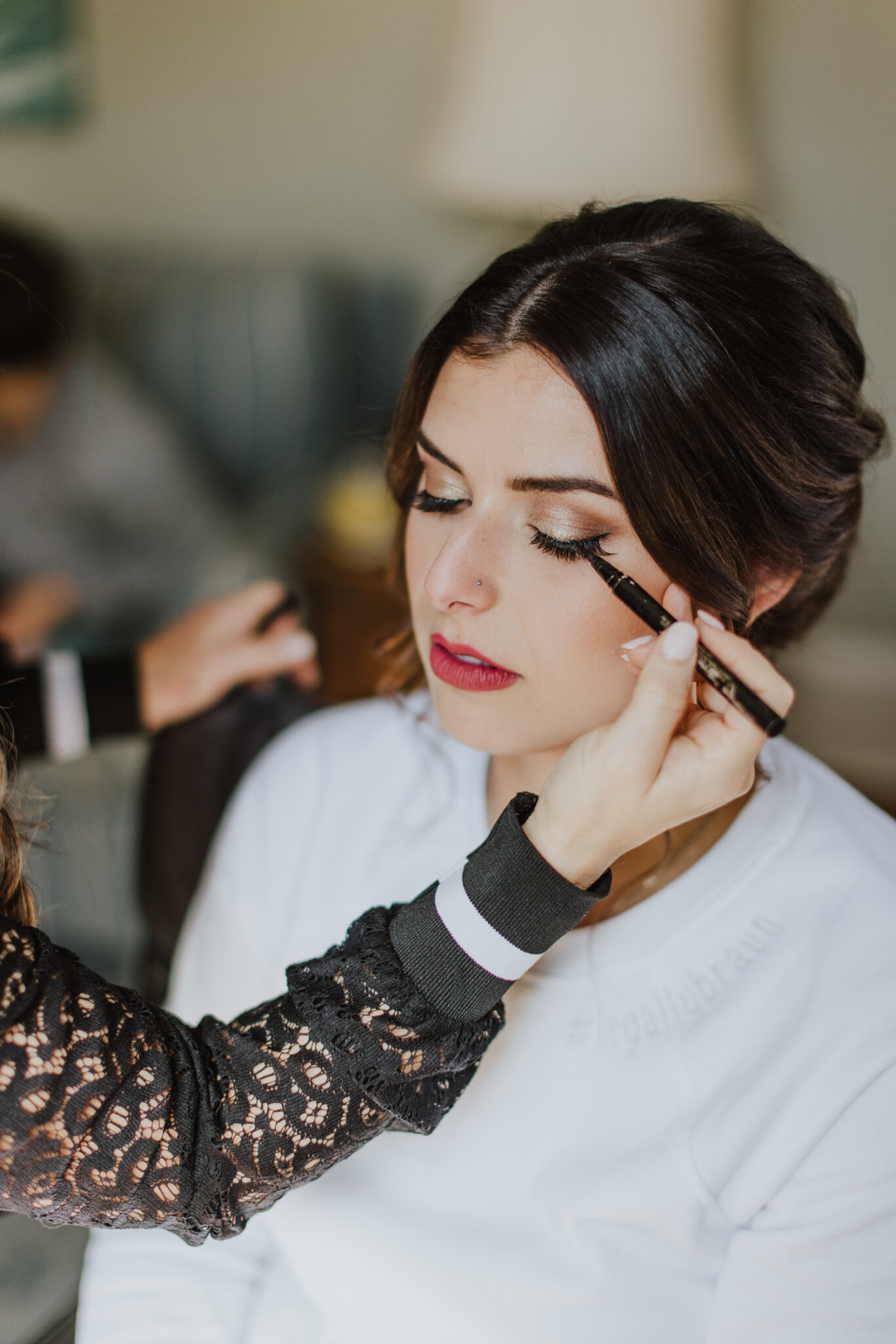 bride getting eye liner professionally applied on her wedding day