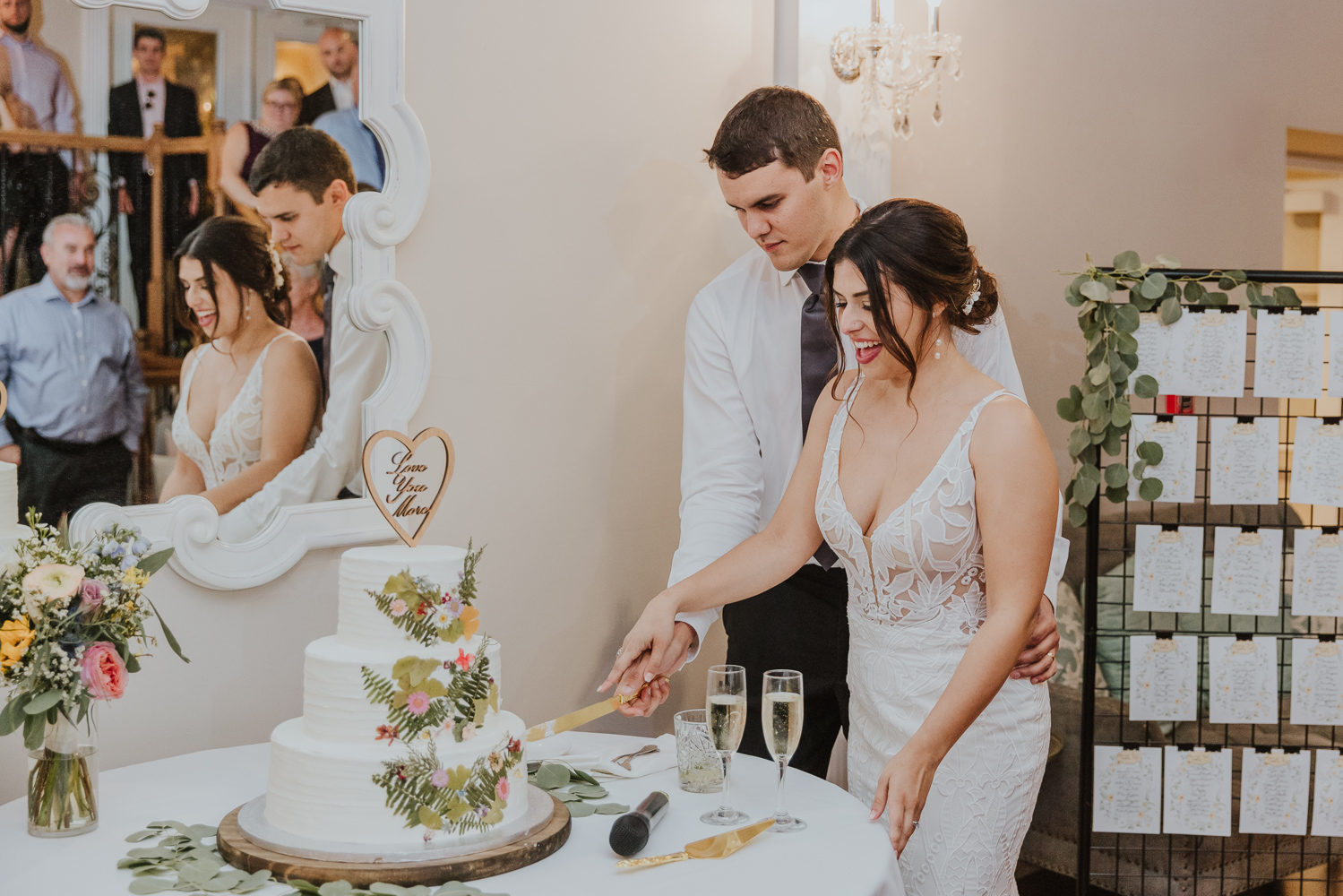 groom and bride cutting their cake during their reception at the white room loft and rooftop