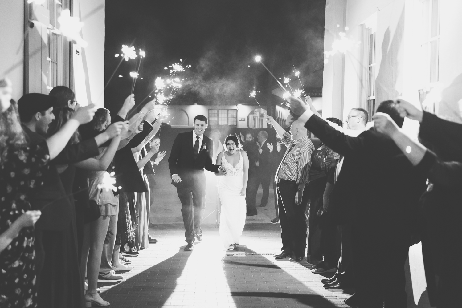 groom and bride walking down the alley to their sparkler exit at the white room 