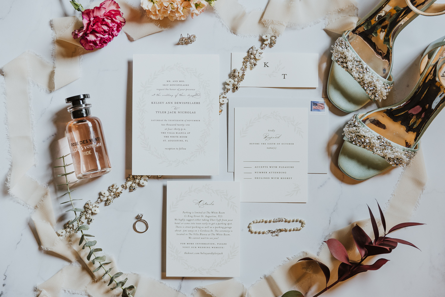 wedding invitations and bridal details laid out together 