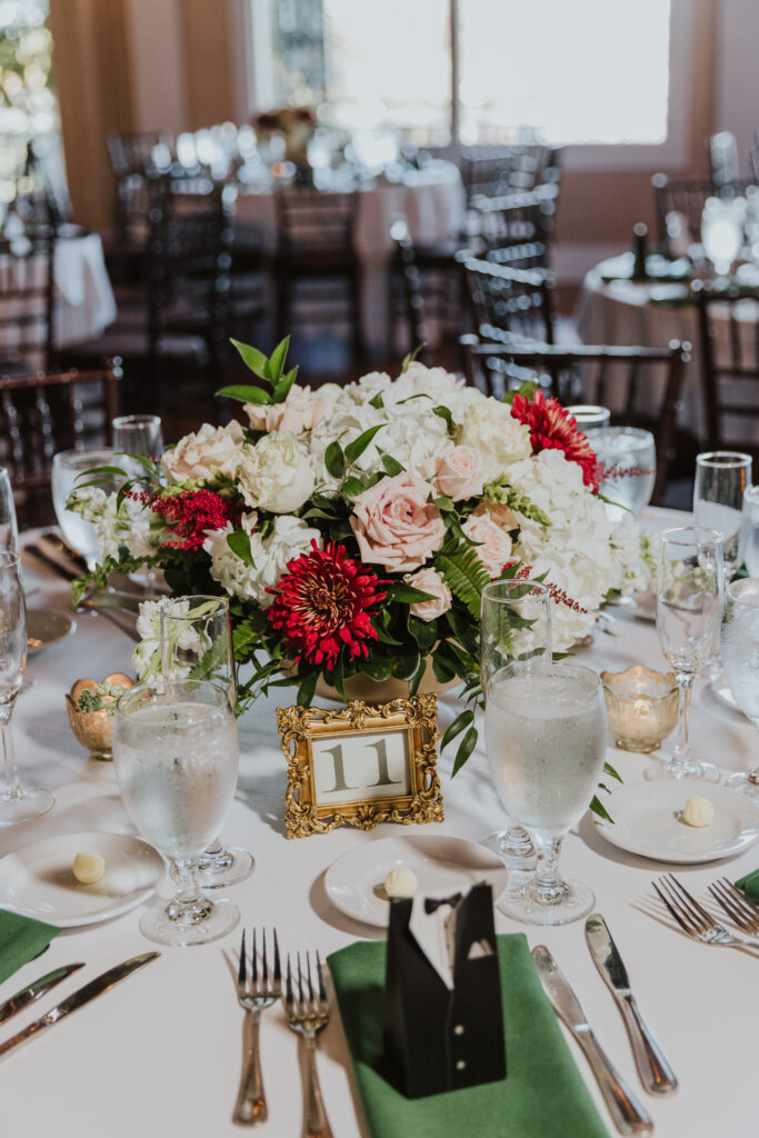 wedding centerpiece with white, pink and red florals and greenery.