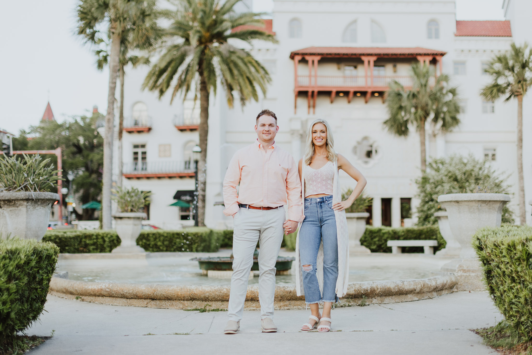 couple standing in front of fountain of lightner museum with casa monica in background
