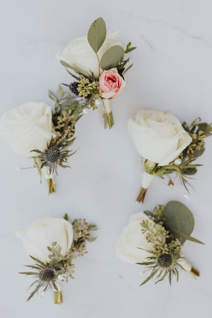 wedding boutonnieres with white roses and thistle