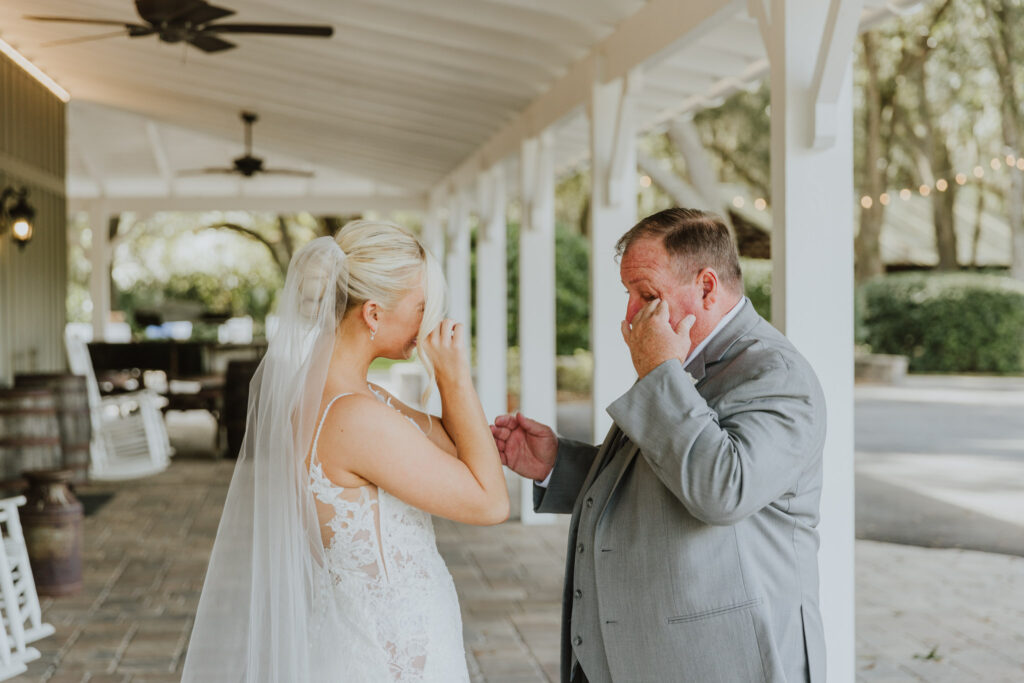 bride and her father wiping away tears during their first look before the ceremony