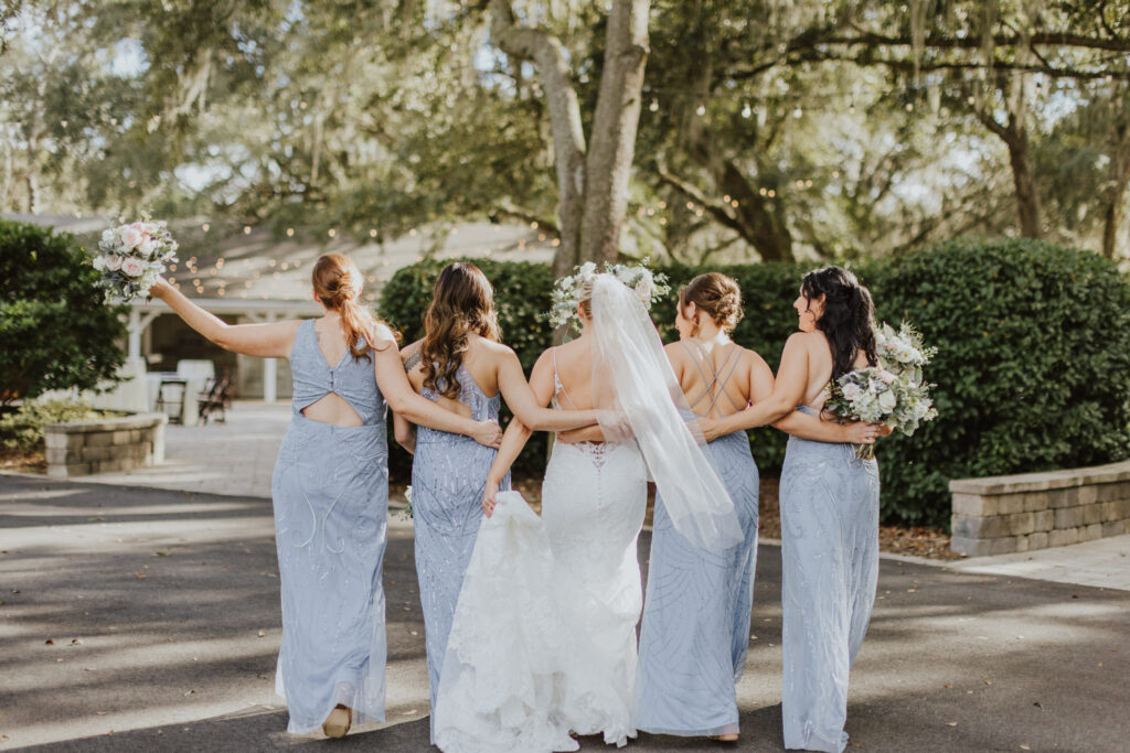 bride and her bridesmaids walking way towards the bowing oaks patio in jacksonville fl
