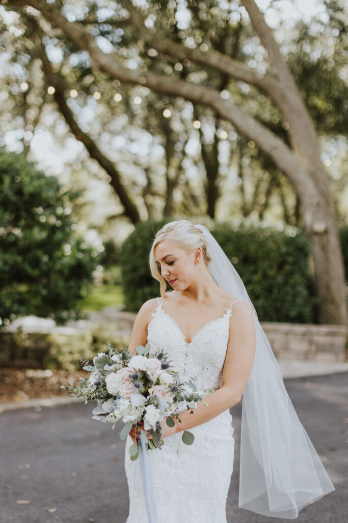 bride looking down at bouquet during outdoor bridal portraits
