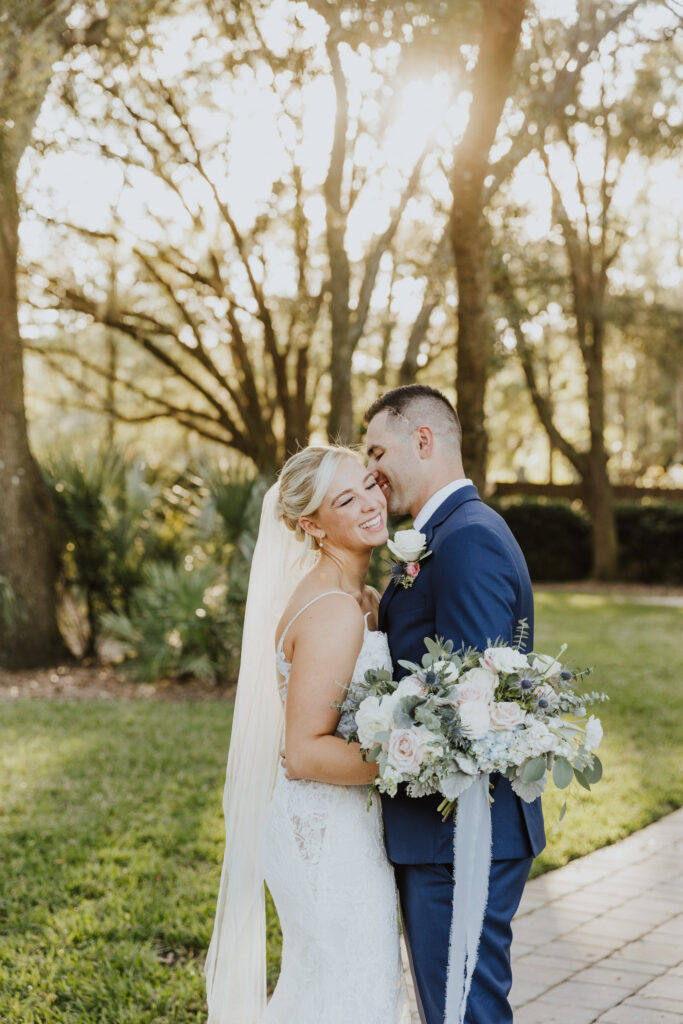bride and groom snuggling into each other outside during wedding portraits