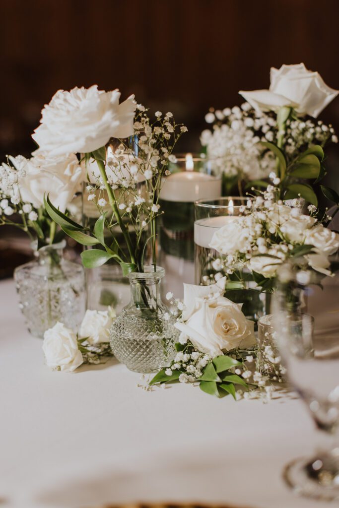 white florals and candle centerpiece with glass vases. 