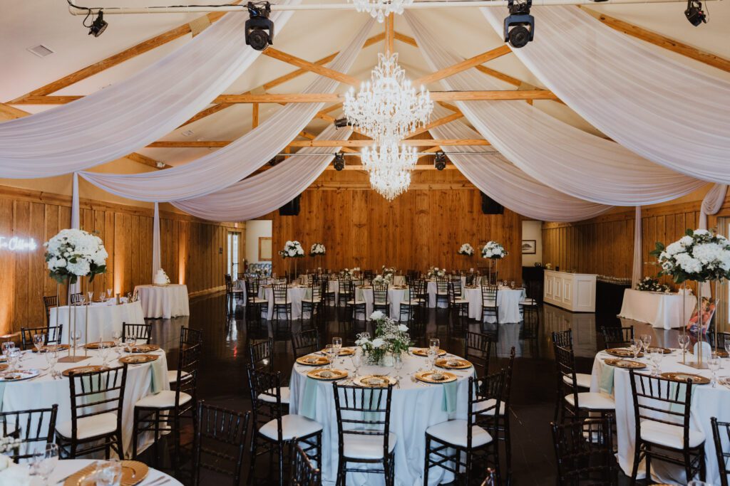 bowing oaks wedding venue set up for a wedding reception inside with white linens and center dance floor. 