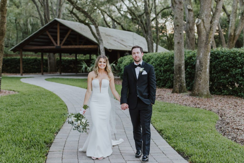 the bride and groom standing in the bowing oaks outdoors walkway