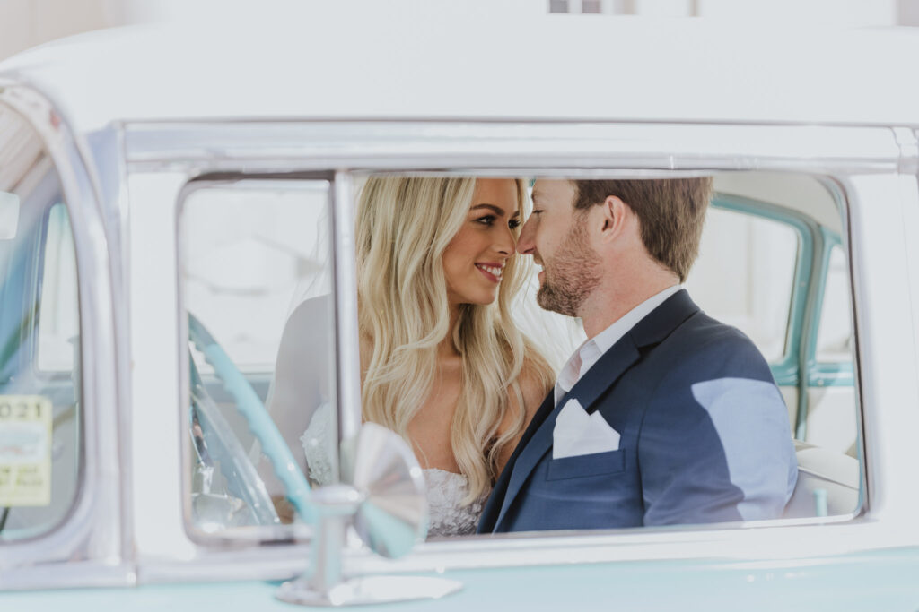 bride and groom looking at each other sitting in classic car