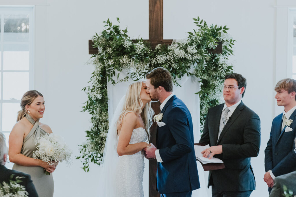 bride and groom sharing their first kiss during their ceremony at the white room villa blanca in st. augustine