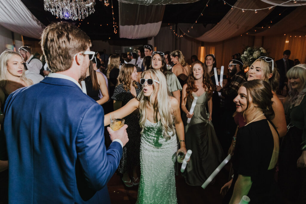 bride wearing glasses in middle of wedding reception dance floor 