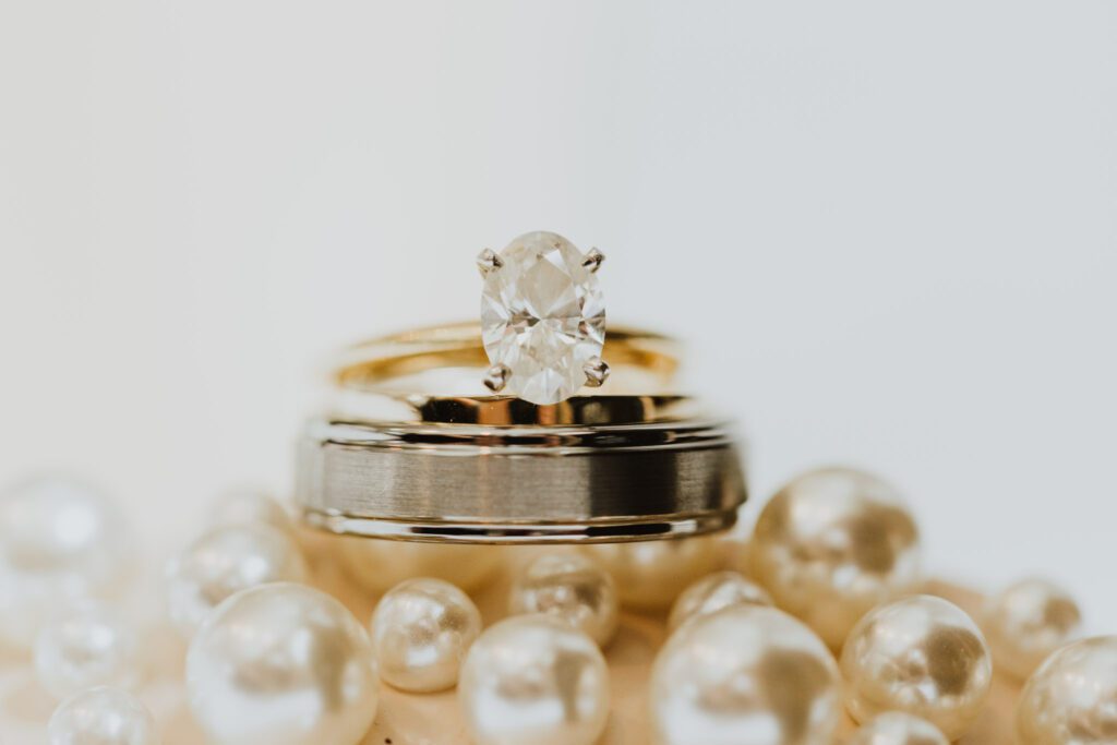 engagement ring and wedding bands on pearls