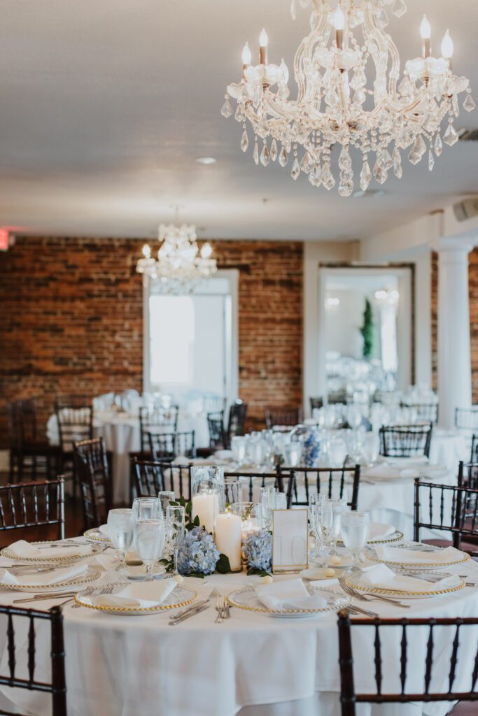 white room loft set up for reception with blue and white centerpieces 