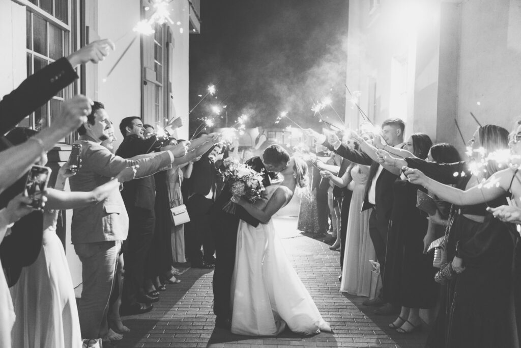 bride and groom kissing in middle of grand sparkler exit at the white room 